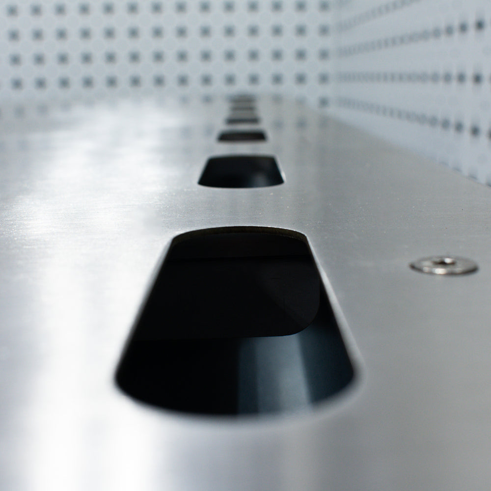 Close-up of a metallic surface with black conical objects on a grid-patterned background