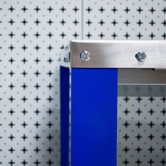Metallic object with blue panel against a patterned background