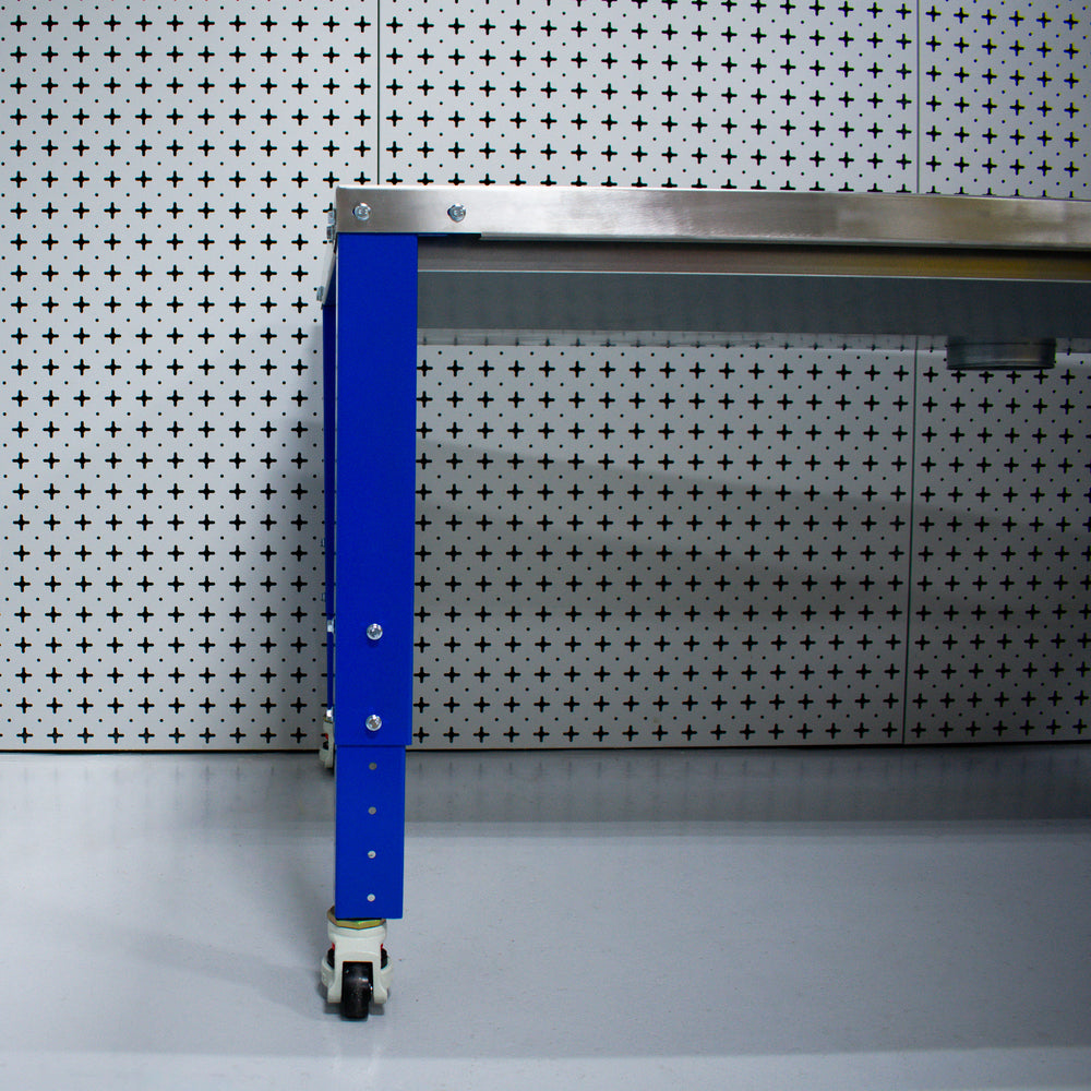 Metal workbench with blue leg against a patterned wall.