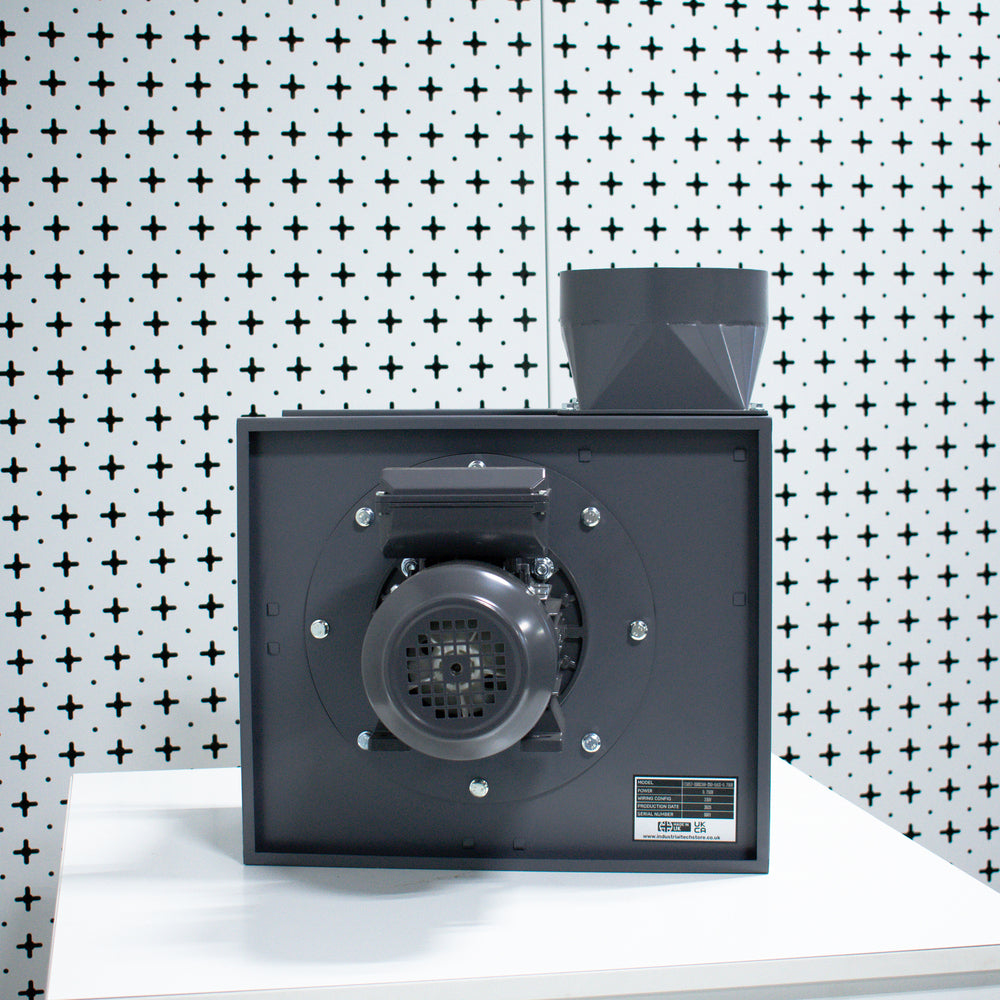 Black rectangular centrifugal fan on a white surface with a patterned wall in the background