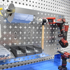 Wall-mounted tool organizer with tools and storage bins on a pegboard.