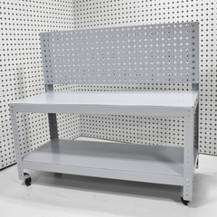 Metal workbench with pegboard against a patterned wall