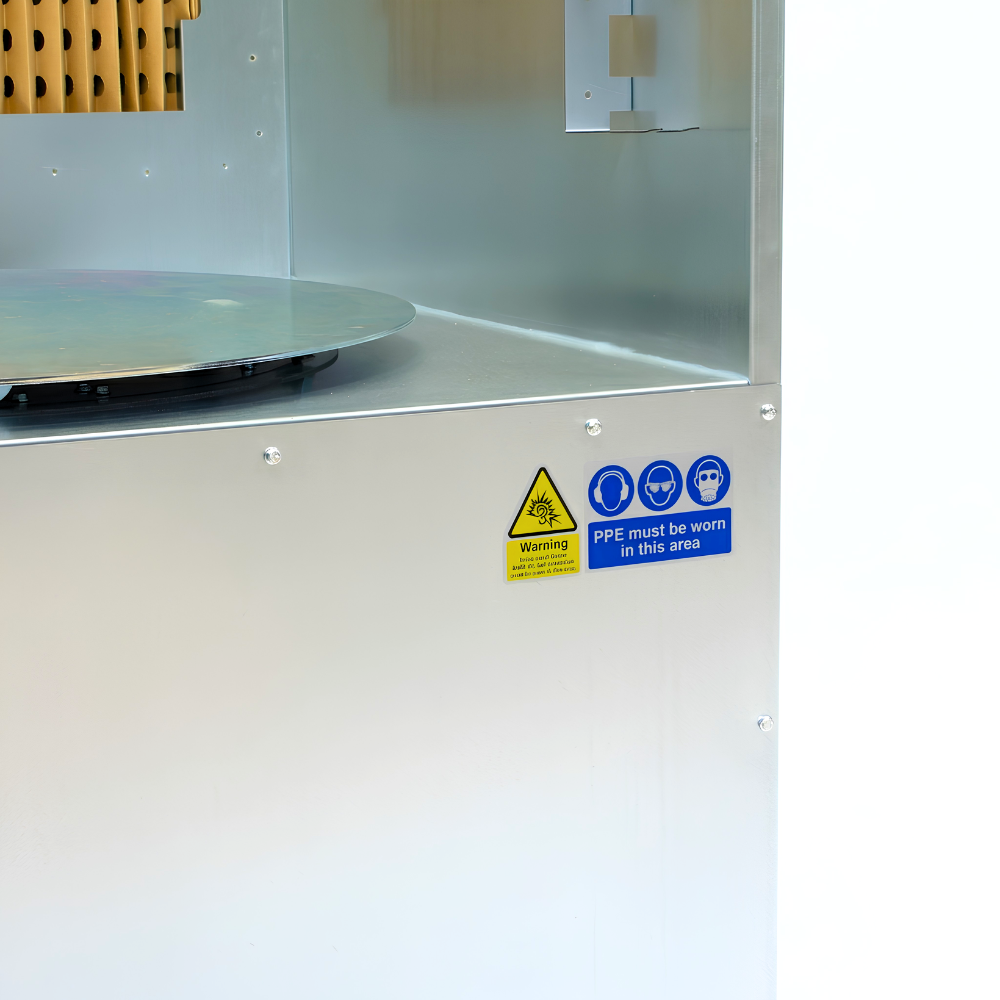 Safety signs and PPE information on Industrial ATEX spray booth with turntable on white background