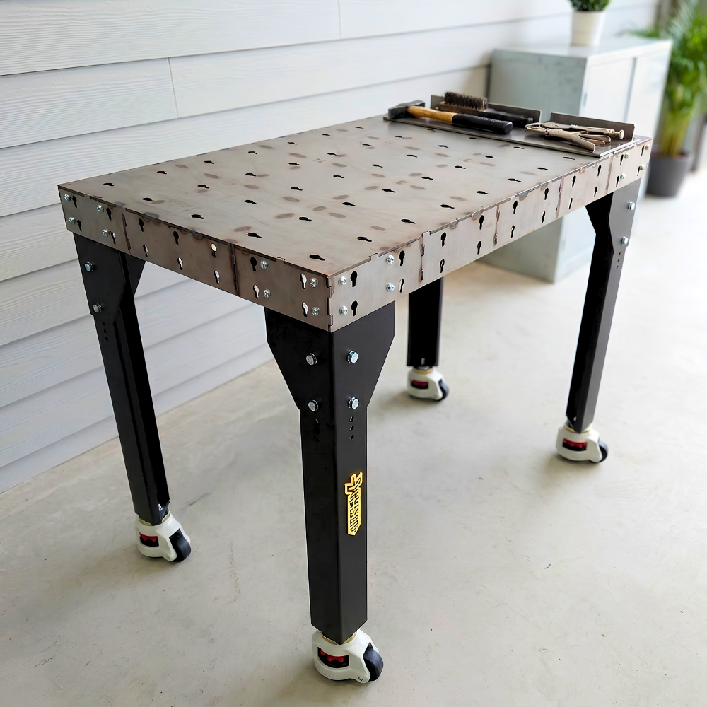 Welding table with black legs setup in an outside workshop