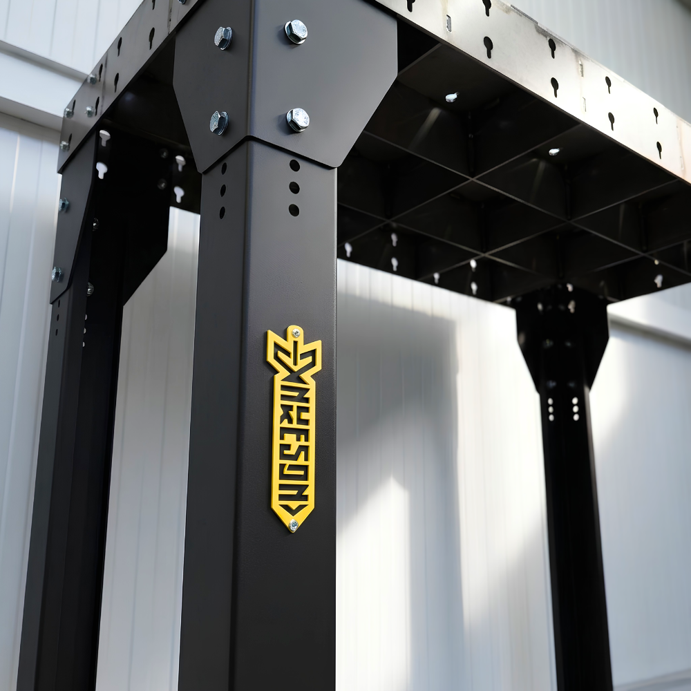 Welding table with black legs and a yellow nukeson plaque
