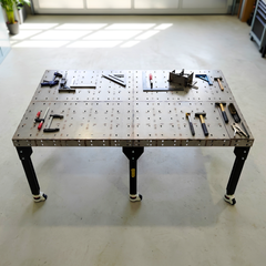 Large welding table with black legs in a modern workshop