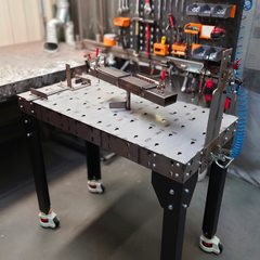Welding table with black legs and welding tools in an industrial workplace