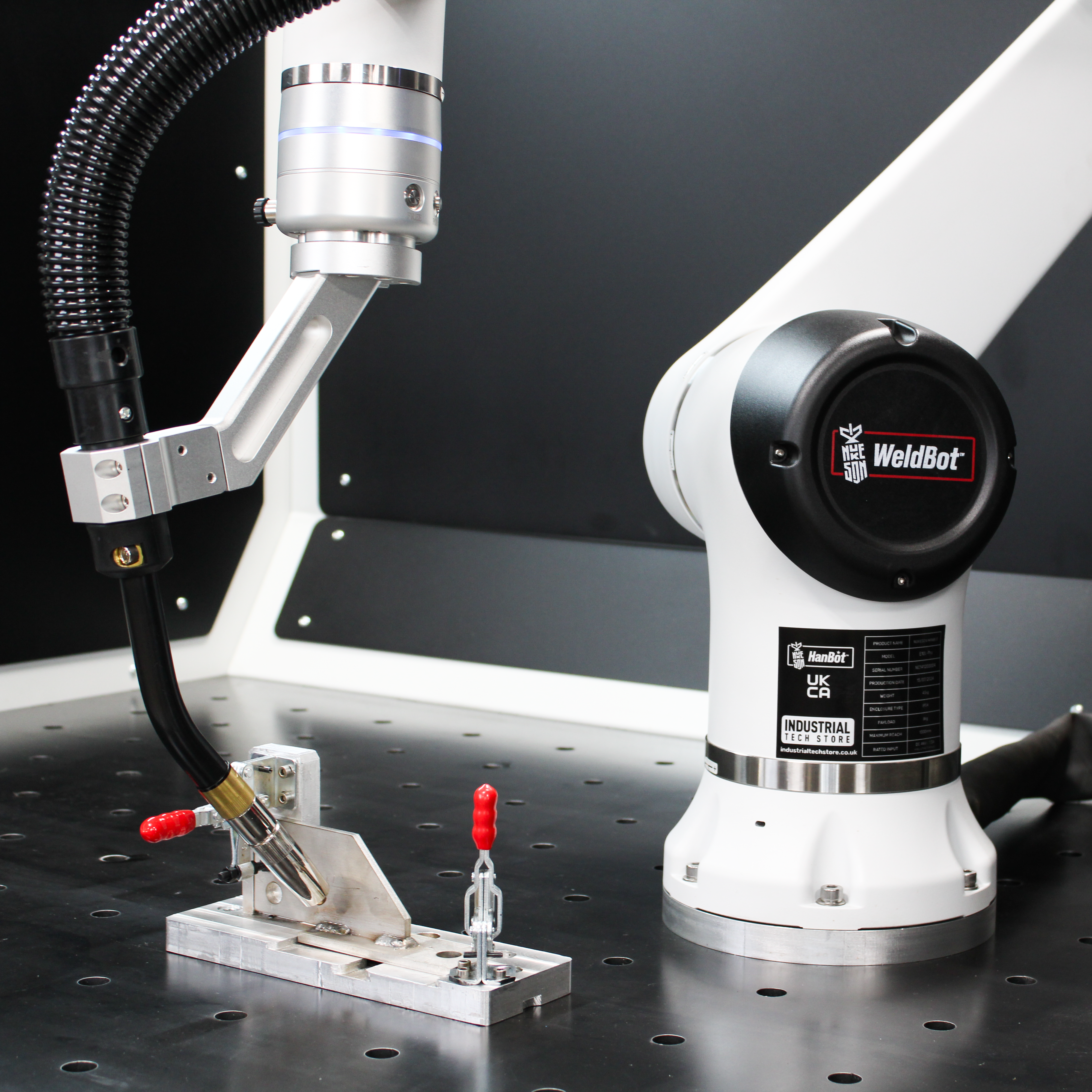 WeldBot robotic arm with MIG welding torch on D16 steel fixture table