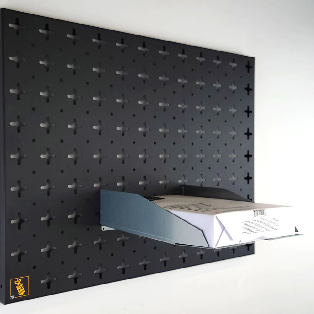 Pegboard paper tray, in galvanised steel with a stack of paper in, on a black pegboard organiser wall