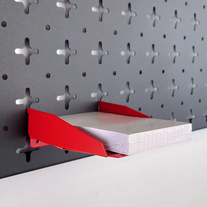 Pegboard paper tray, in red with an A6 note stack in, on a black pegboard organiser wall