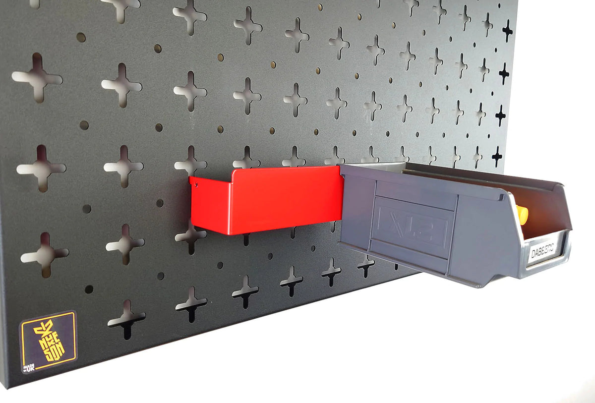 A red Nukeson tool wall XL box holding bracket, with a black plastic XL storage box attached, mounted on a black wall organiser panel