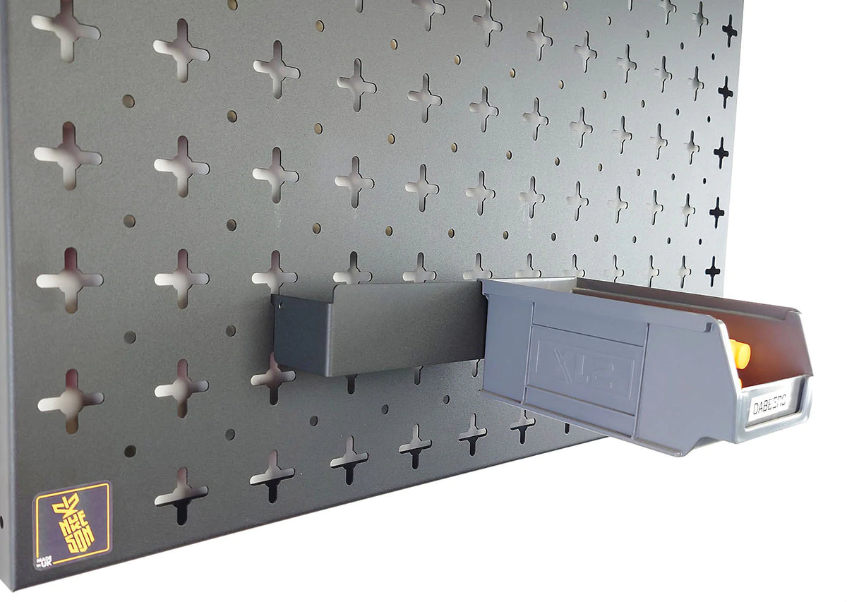 A black Nukeson tool wall XL box holding bracket, with a black plastic XL storage box attached, mounted on a black wall organiser panel