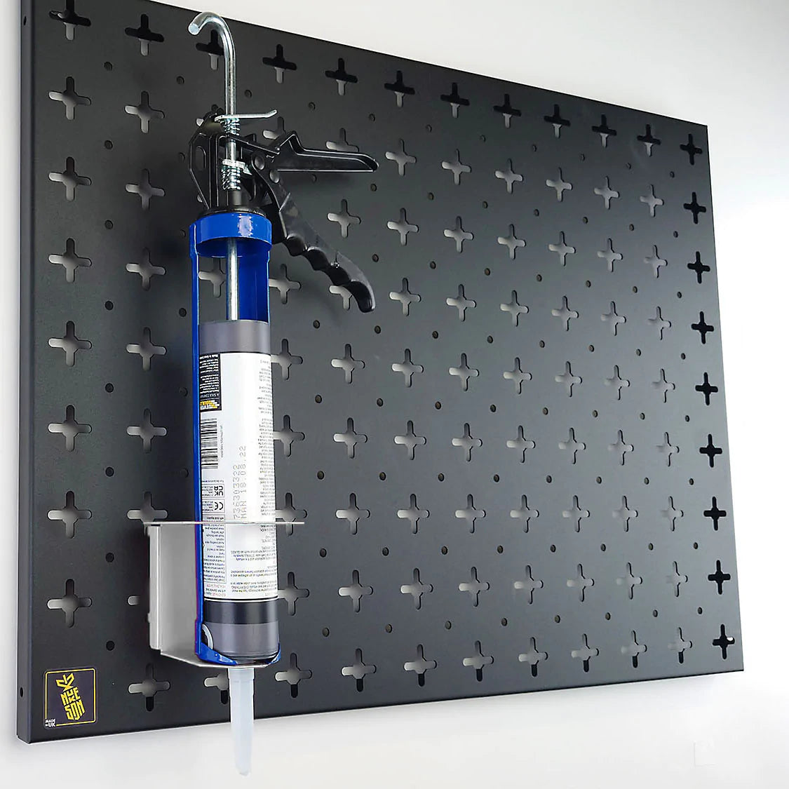 Nukeson Tool Wall silicone tube holder in White, with silicone gun attached, mounted on black organiser